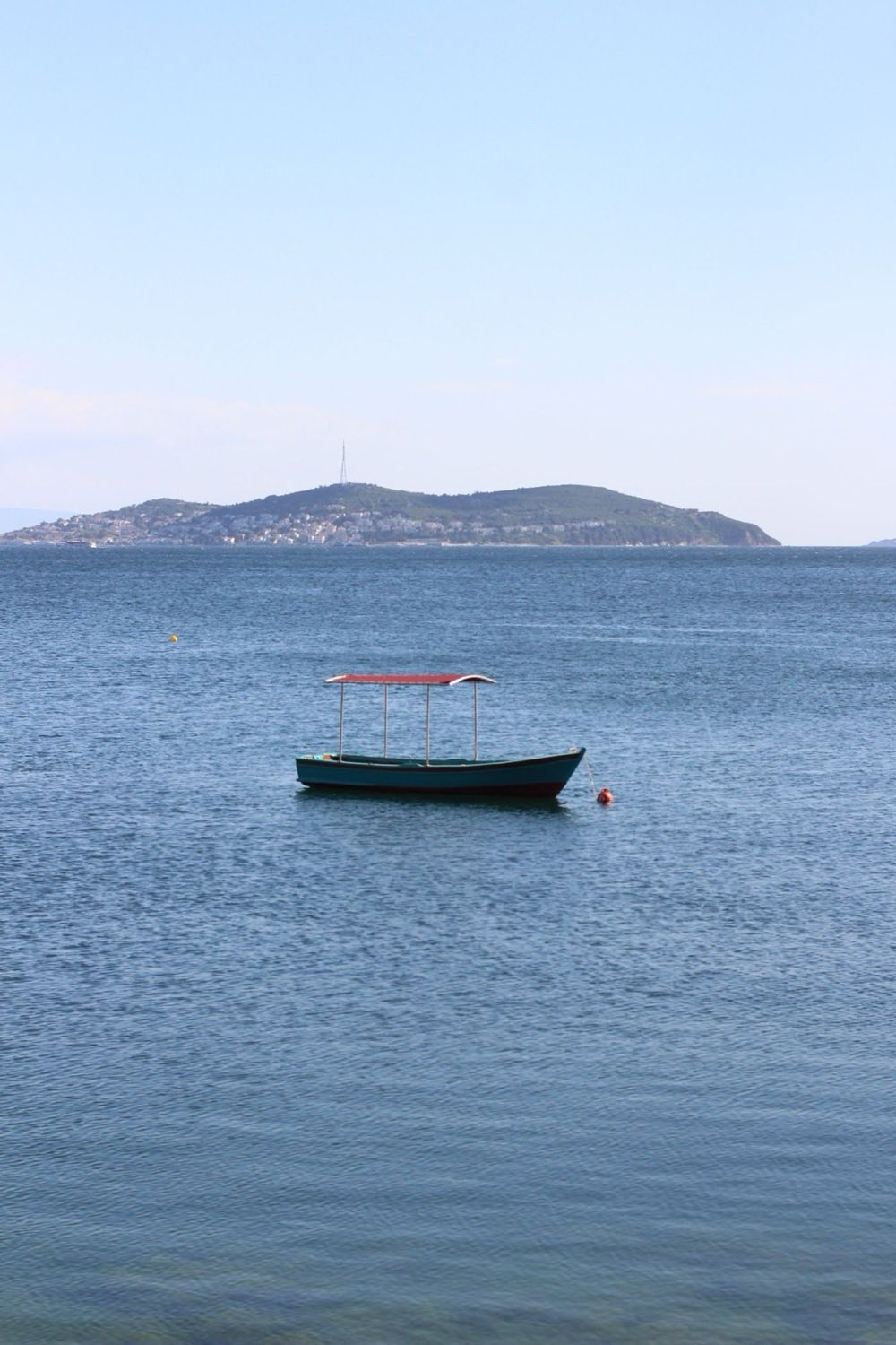 Mer calme au large, avec une île à l'horizon
