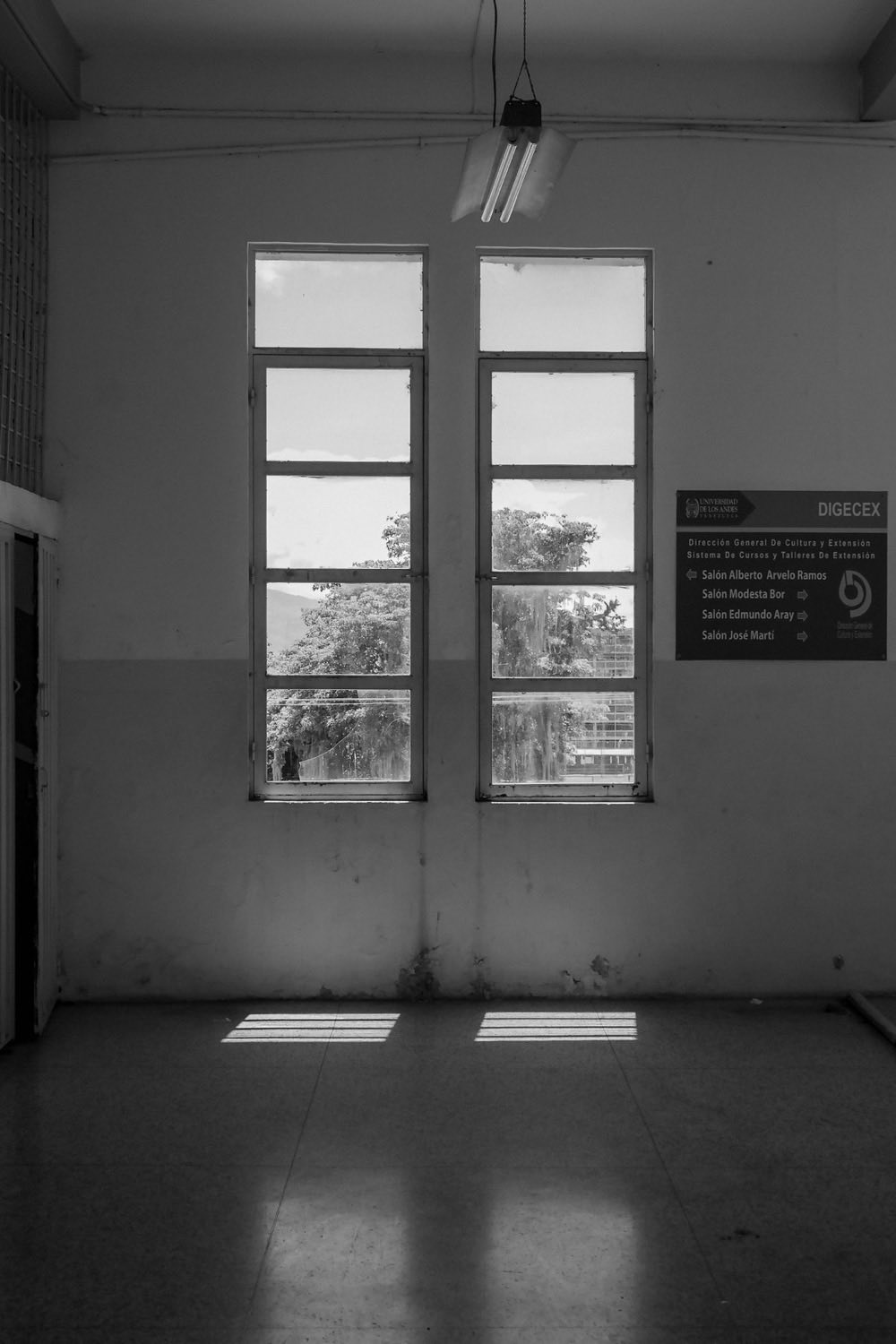 Intérieur épuré en noir et blanc traversé par la lumière de deux fenêtres